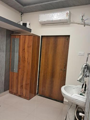 a bathroom with two wooden doors and a sink at Sea view villa in Kondivli