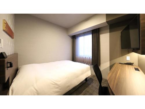 金沢市にあるSmile Hotel Kanazawa Nishiguchi Ekimae - Vacation STAY 24204vのベッドと窓のあるホテルの部屋