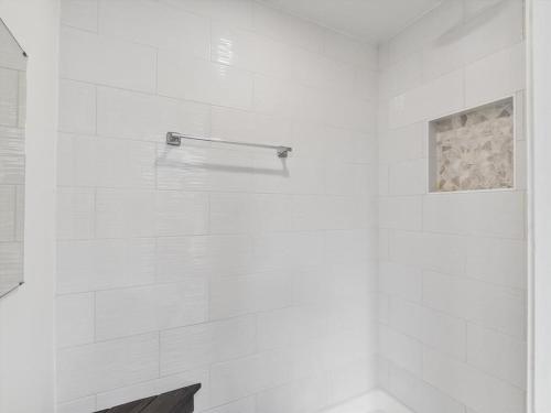 a bathroom with a shower with a white tile wall at Beach House with Rooftop Deck by Leavetown Vacations in Bethany Beach