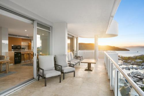 a balcony with chairs and a view of the ocean at Luxury Hamilton Island Sub Penthouse on Level 12 & Buggy & Transfers in Hamilton Island