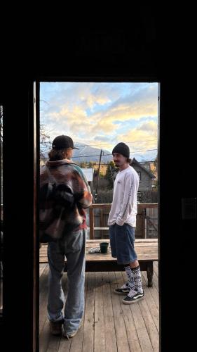 two men standing on a deck looking at a painting at Alaska Patagonia Hostel in San Carlos de Bariloche