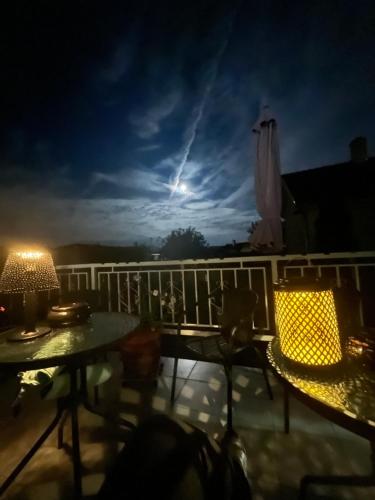 a view of a balcony at night with two tables at Kuruc Apartman in Sopron