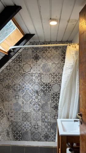 a bathroom with a sink and a tiled wall at Alaska Patagonia Hostel in San Carlos de Bariloche