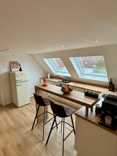 a kitchen with two windows and a counter with two chairs at Lupi Blue - stilvoll und cosy Appartment in Buchen