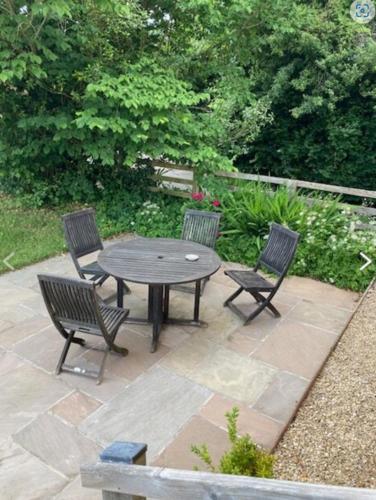 a patio with a table and four chairs at Brynderwen Barn in Llangorse