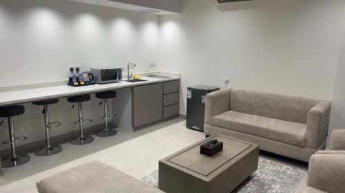 a living room with a couch and a table and a counter at شقق جولدن إن للشقق المخدومة بجوار مستشفي السعود الالماني in Khamis Mushayt