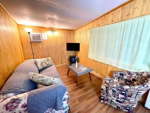 una sala de estar con un sofá y una mesa en 2-Bedroom Cottage #9 - Ambleside, en Kawartha Lakes