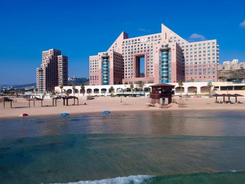 a view of a beach with buildings in the background at Almog Beach apt Hotel מלון דירות אלמוג ביץ' in Haifa