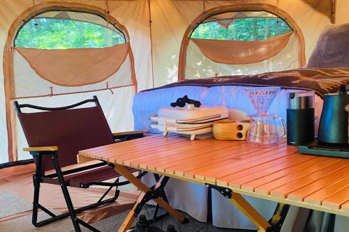 a table in front of a tent with a wooden table sidx sidx at TOCORO. Mt.Fuji CAMP & GLAMPING - Vacation STAY 23398v in Oishi