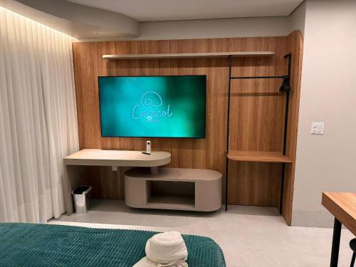 a bedroom with a tv on a wall with a bed at Apartamentos Exclusivos no Edifício City House in Barreiras