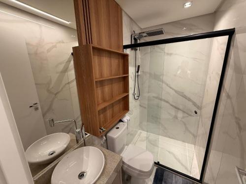 a bathroom with a toilet and a sink and a shower at Apartamentos Exclusivos no Edifício City House in Barreiras