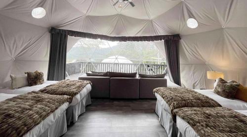 a bedroom with two beds and a couch in it at TOCORO. Mt.Fuji CAMP & GLAMPING - Vacation STAY 23387v in Oishi