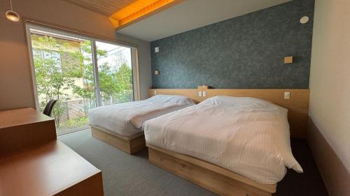 une chambre avec deux lits et une fenêtre dans l'établissement Trihaku Karuizawa Kagura - Vacation STAY 23735v, à Oiwake