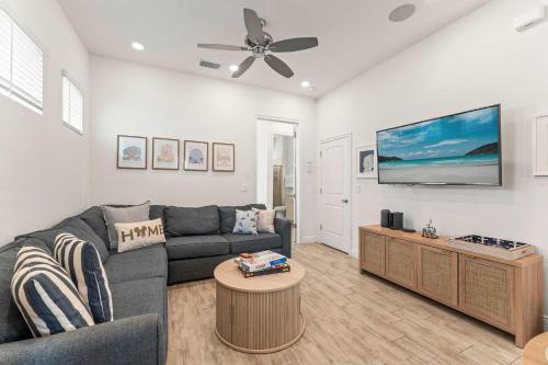 a living room with a couch and a flat screen tv at The Flamingo Nest - Kid Friendly in Orlando