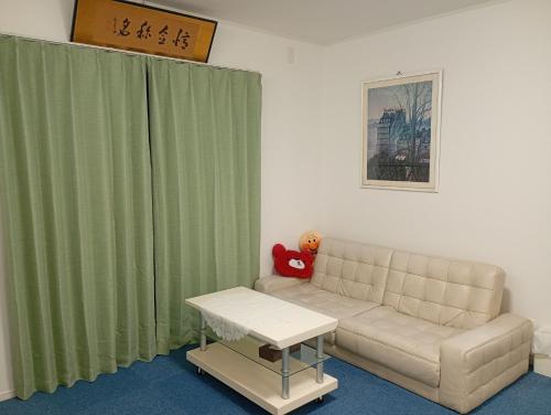 a living room with a couch and a green curtain at ShirokumaHouse - Vacation STAY 24594v in Wakayama
