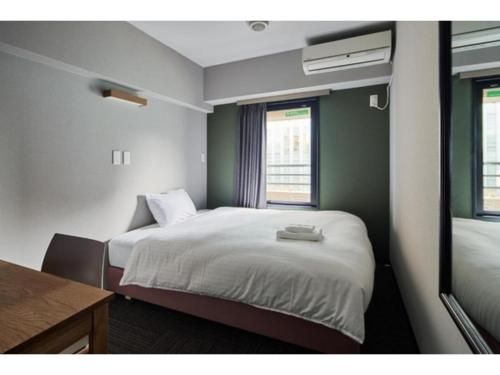 a small room with a bed and a window at HOTEL STARRIZE - Vacation STAY 25108v in Fukuoka