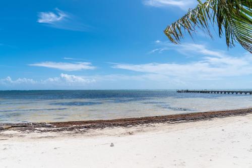 a view of the beach with a pier in the water at Residences at Barrier Reef Casita 3 by Stay Floreo in San Pedro Island