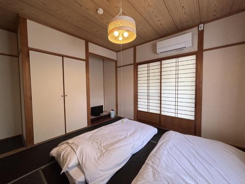 a bedroom with two beds and a chandelier at ChillOut MINAMIASO - Vacation STAY 25172v in Minami Aso