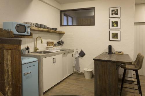 a kitchen with a sink and a table and a microwave at Ander en ValQuirico in Santeagueda