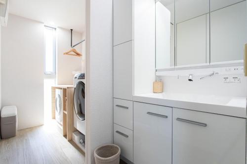 a white kitchen with white cabinets and a washing machine at CAN LI ASSO - Vacation STAY 25193v in Minami Aso