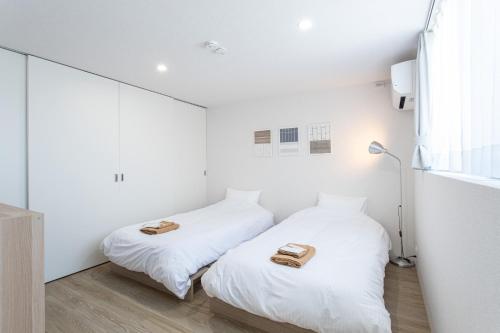 two beds in a white room with towels on them at CAN LI ASSO - Vacation STAY 25225v in Minami Aso