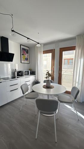 a white kitchen with a white table and chairs at AirStay Orly T3 - Aéroport 10 min - Paris 20 min - Disney 30 min - Rungis in Orly