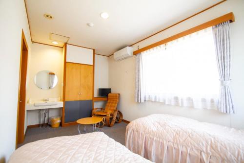 a bedroom with two beds and a sink and a mirror at Kanon suisha - Vacation STAY 26689v in Kawaba