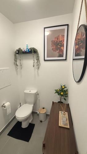 a bathroom with a toilet and a table and a mirror at AirStay Orly T3 - Aéroport 10 min - Paris 20 min - Disney 30 min - Rungis in Orly