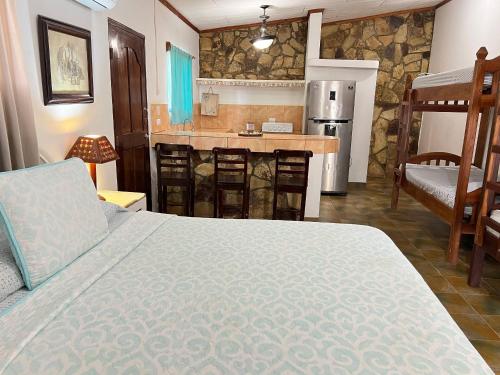 a bedroom with a bed and a kitchen with a counter at Hostel Sunset Villas Popoyo in Popoyo