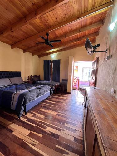 a bedroom with two beds and a flat screen tv at Virgen Del Valle Alojamiento in Tafí del Valle