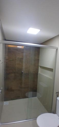 a bathroom with a glass shower and a toilet at Casa praia Paracuru in Paracuru