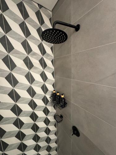 a bathroom with a black and white tiled shower at Modern apartment with a beautiful panoramic view in Bogotá