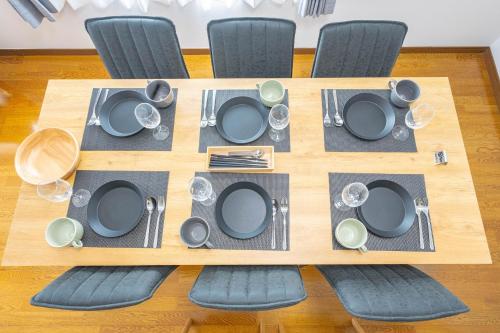 a wooden table with chairs and a table set with plates and dishes at Soyo in Tsumagoi