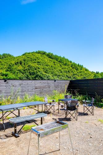 a group of tables and chairs in a garden at Soyo in Tsumagoi