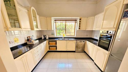 a kitchen with white cabinets and a sink at Peaceful escape with private pool in Mellieħa