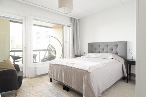 a white bedroom with a bed and a window at Modern 2BR apartment W 2 balconies, Metro, Helsinki 15min in Espoo