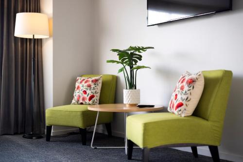 two chairs and a table in a hotel room at Hotel Give in Christchurch