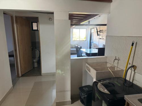 メデジンにあるApartamento cómodo con excelente ubicaciónのキッチン、リビングルームが備わります。
