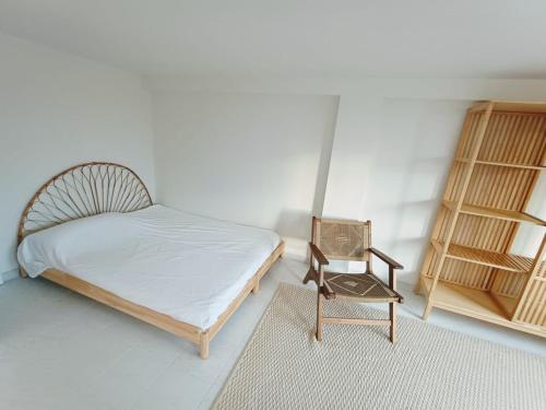 a small bedroom with a bed and a chair at LOFT ROYAL - apartamento "loft" con terraza y vistas al mar in Faro de Cullera