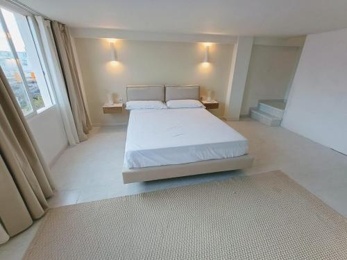 a bedroom with a bed and a large window at LOFT ROYAL - apartamento "loft" con terraza y vistas al mar in Faro de Cullera