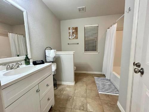 a bathroom with a sink and a mirror and a shower at The Texas Bluebonnet Home in Historic McKinney in McKinney