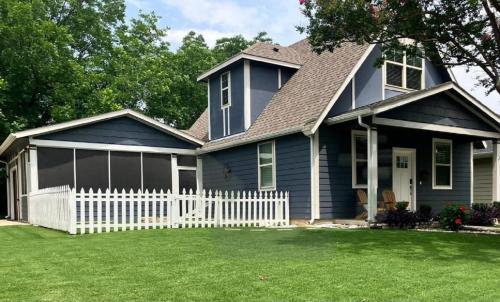 a blue house with a white picket fence at The Texas Bluebonnet Home in Historic McKinney in McKinney