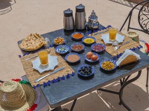 a table with bowls of food and drinks on it at Dar Tamatert in Tamatert