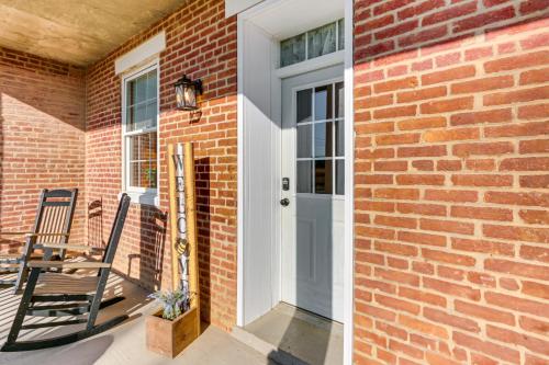a brick house with a white door and a chair at 5,000 Sq Ft Antebellum Farmhouse 3 Mi to Antietam! in Fairplay