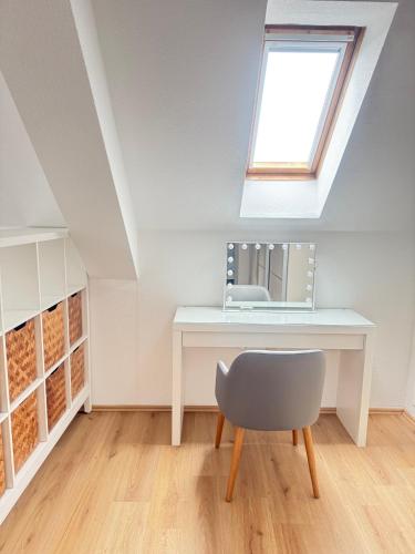 a desk with a mirror and a chair in a attic at FeWo & Monteurwohnungen 2 in Iserlohn