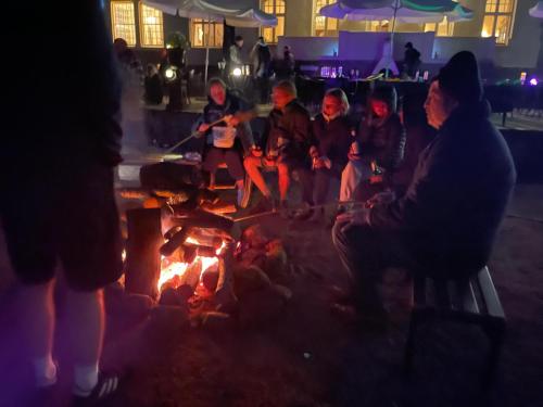 a group of people sitting around a fire at Schloss Krugsdorf Golf & Hotel in Krugsdorf