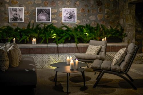 a living room with two chairs and a table and candles at Mezquite by Viadora in San Miguel de Allende