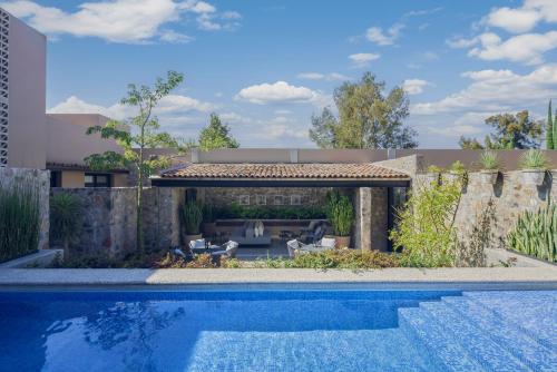 a swimming pool in a yard with a house at Mezquite by Viadora in San Miguel de Allende