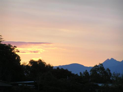 a sunset with mountains in the background at Hazelwood Mapua in Mapua