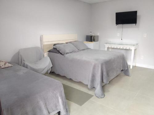 a bedroom with a bed and a flat screen tv at StudioD in Passo Fundo